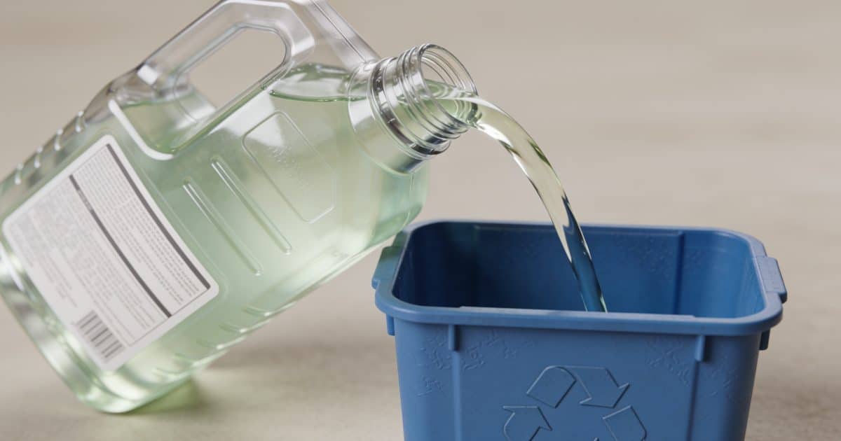 Bidon de liquide de refroidissement verse dans conteneur recyclage