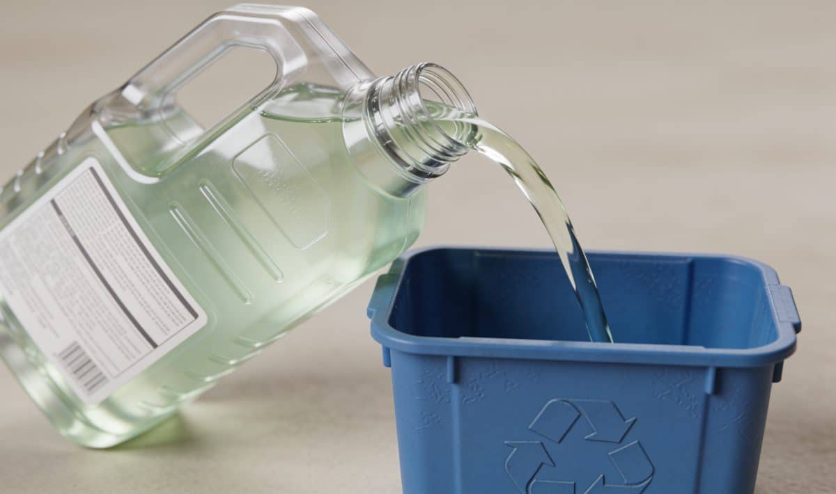Bidon de liquide de refroidissement verse dans conteneur recyclage