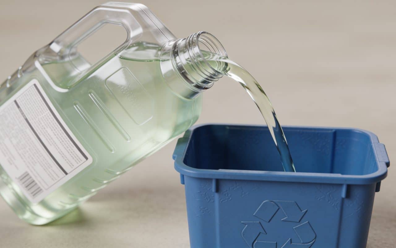 Bidon de liquide de refroidissement verse dans conteneur recyclage