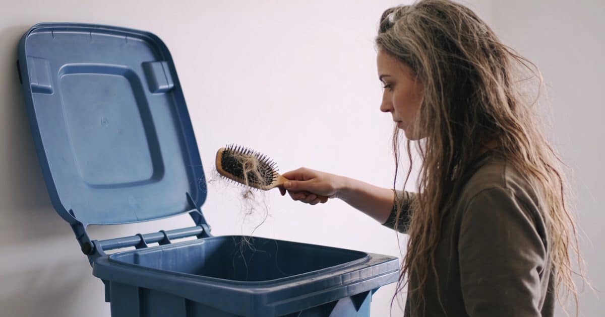 Femme deposant vieux seche cheveux bac recyclage