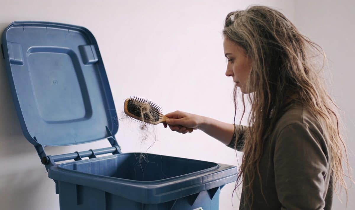 Femme deposant vieux seche cheveux bac recyclage