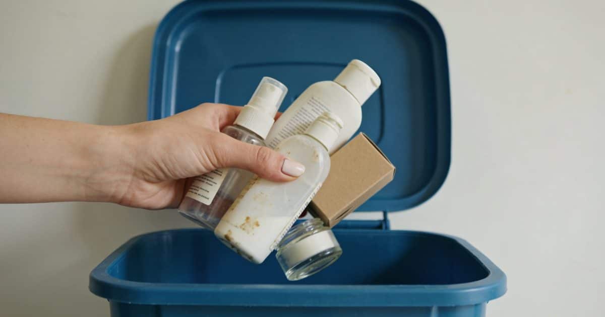 Femme jetant vieux produits cosmétiques dans poubelle recyclage