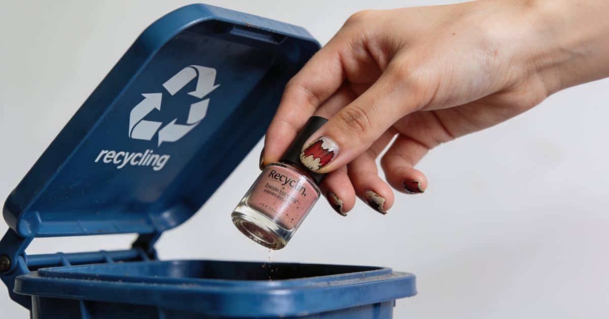 Femme jette vieux vernis a ongles dans bac recyclage