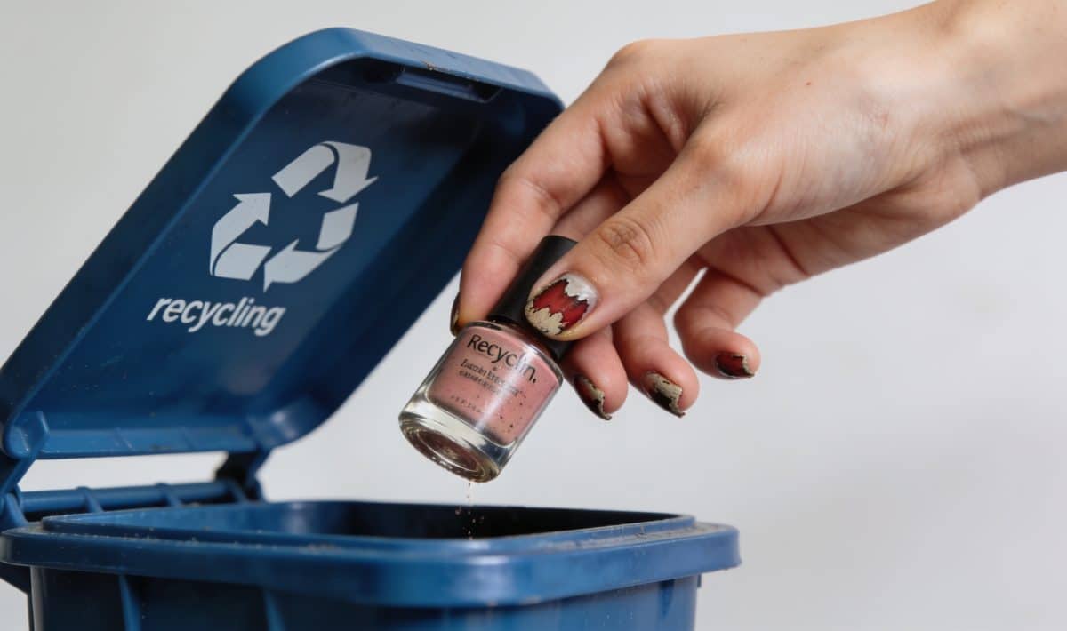 Femme jette vieux vernis a ongles dans bac recyclage