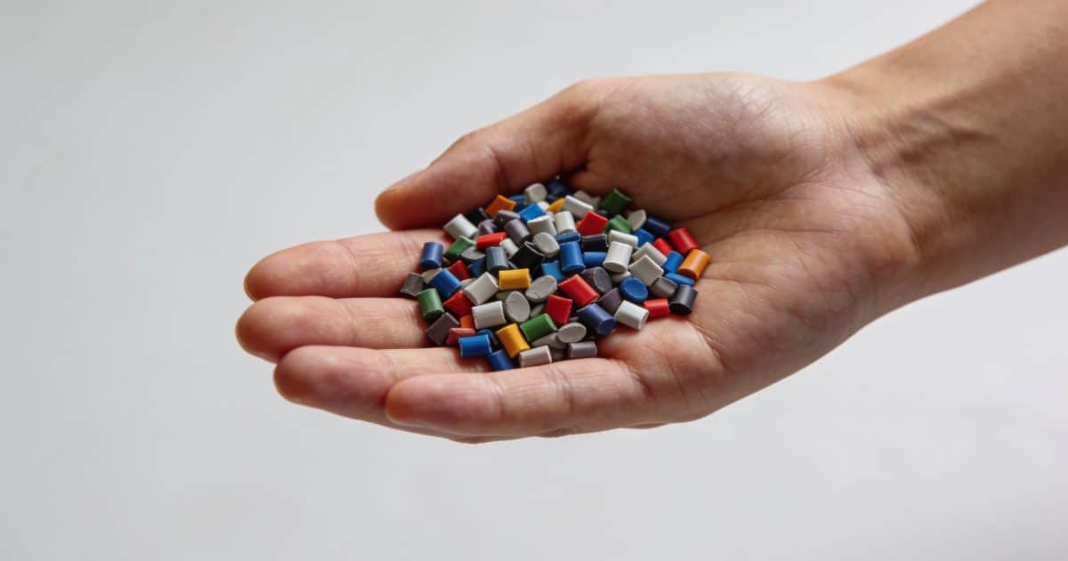 Granules plastiques multicolores ABS dans une main