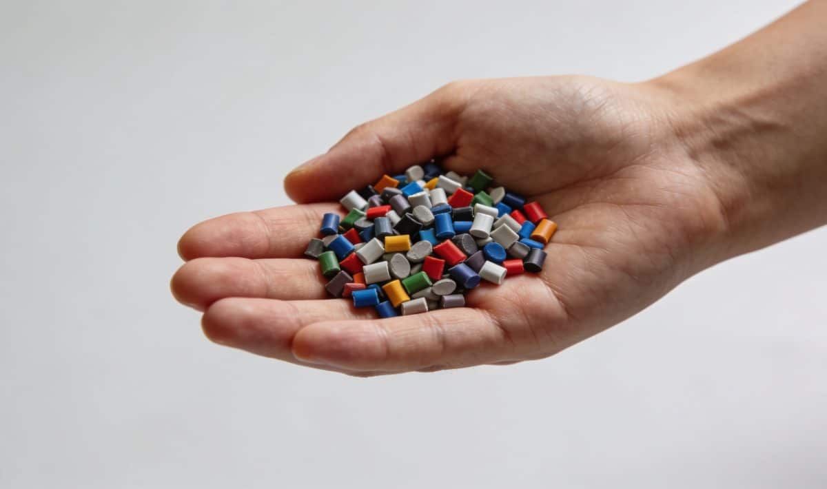 Granules plastiques multicolores ABS dans une main