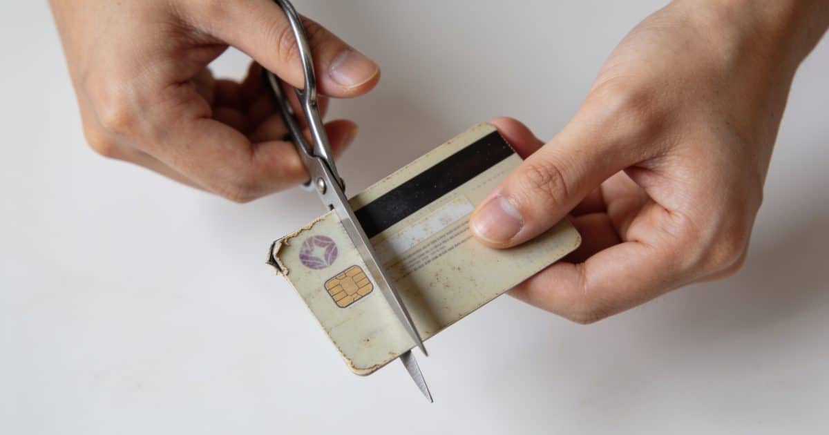 Personne decoupant une vieille carte bancaire inutilisee