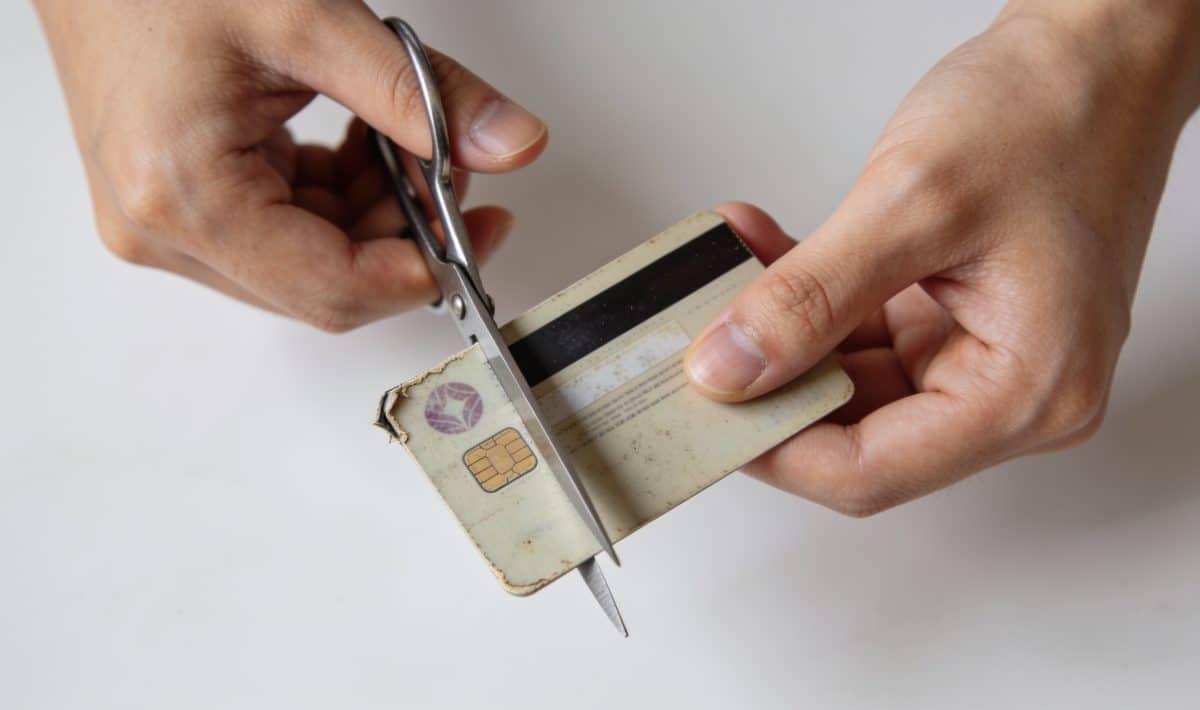Personne decoupant une vieille carte bancaire inutilisee