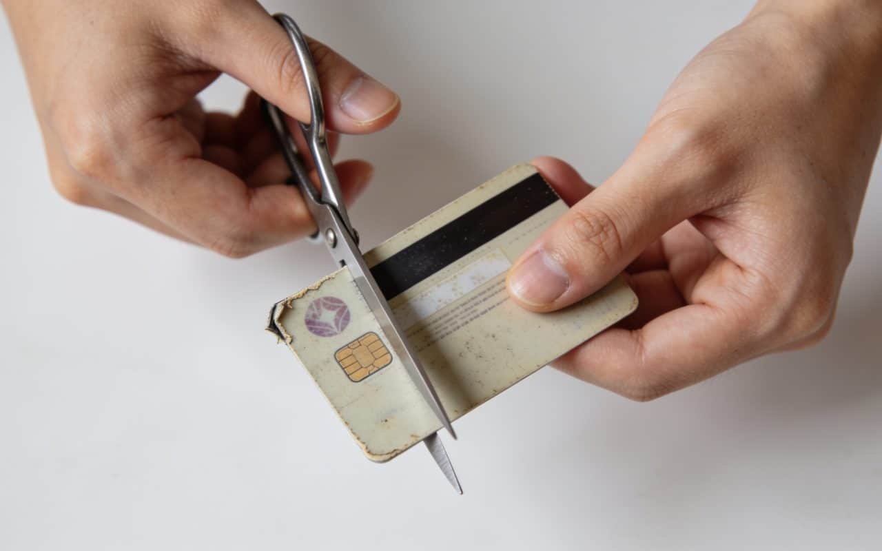 Personne decoupant une vieille carte bancaire inutilisee