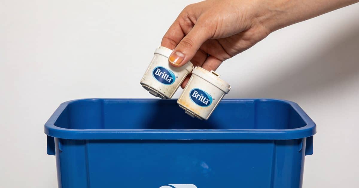 Personne deposant cartouches brita usagees dans bac recyclage