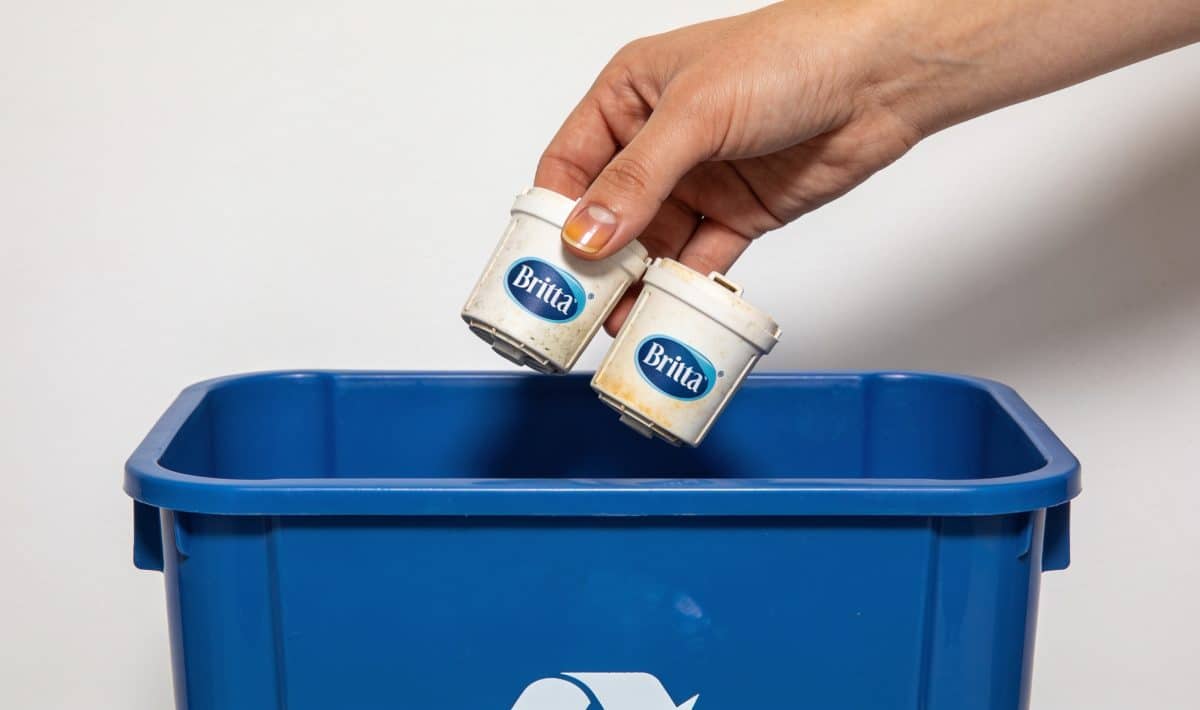 Personne deposant cartouches brita usagees dans bac recyclage