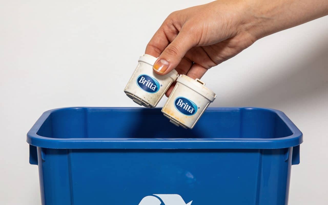 Personne deposant cartouches brita usagees dans bac recyclage