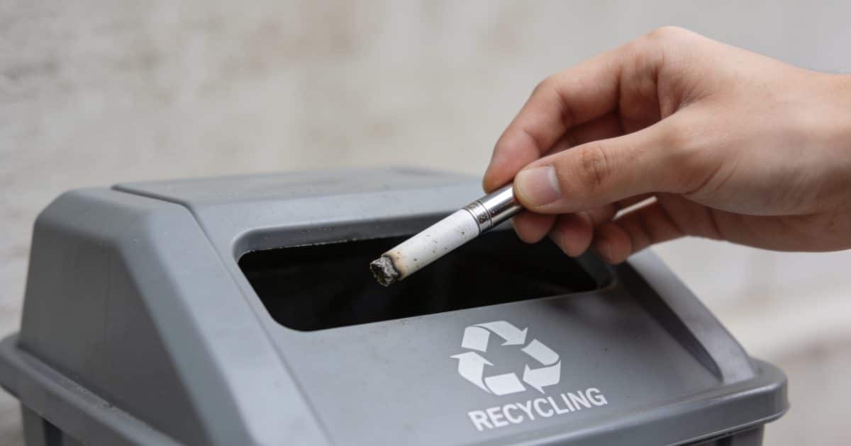 Personne deposant cigarette electronique usagee dans borne recyclage