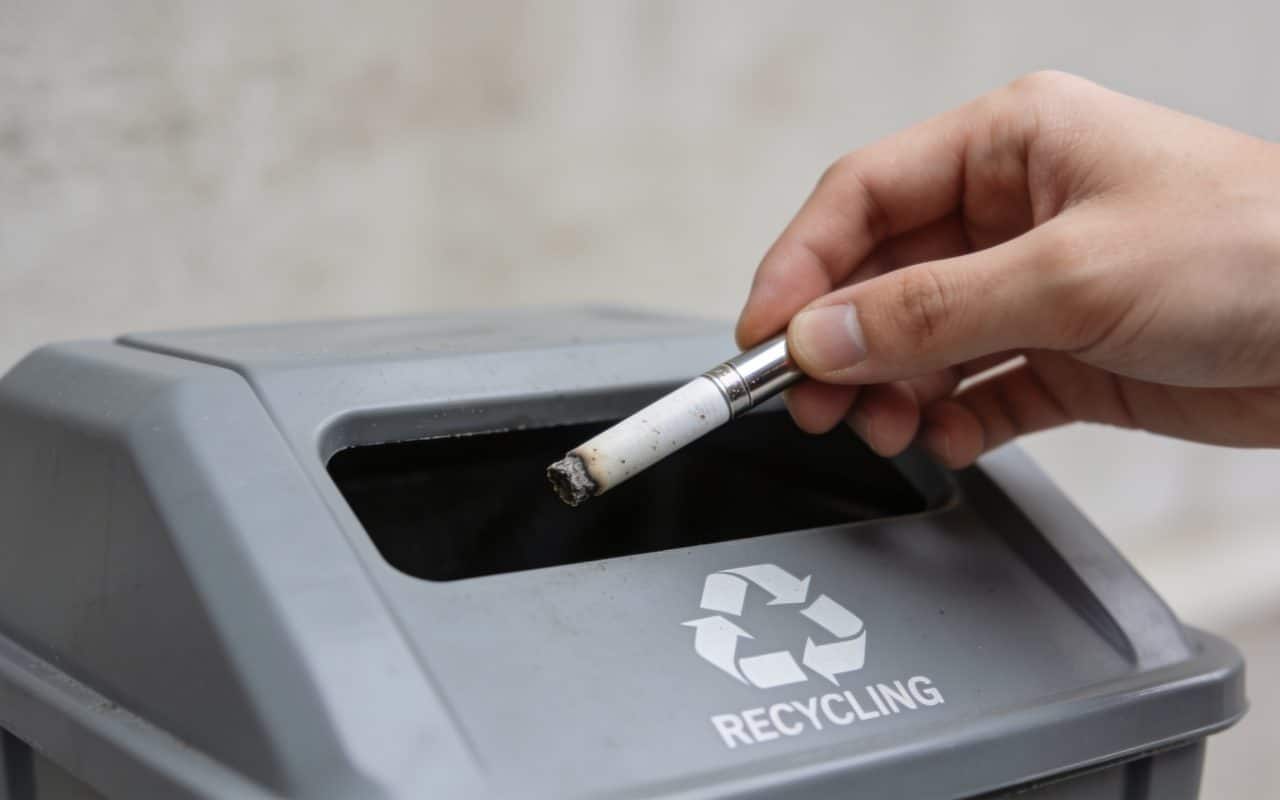Personne deposant cigarette electronique usagee dans borne recyclage