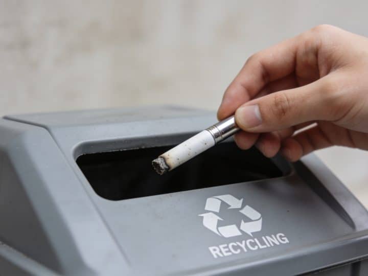 Personne deposant cigarette electronique usagee dans borne recyclage