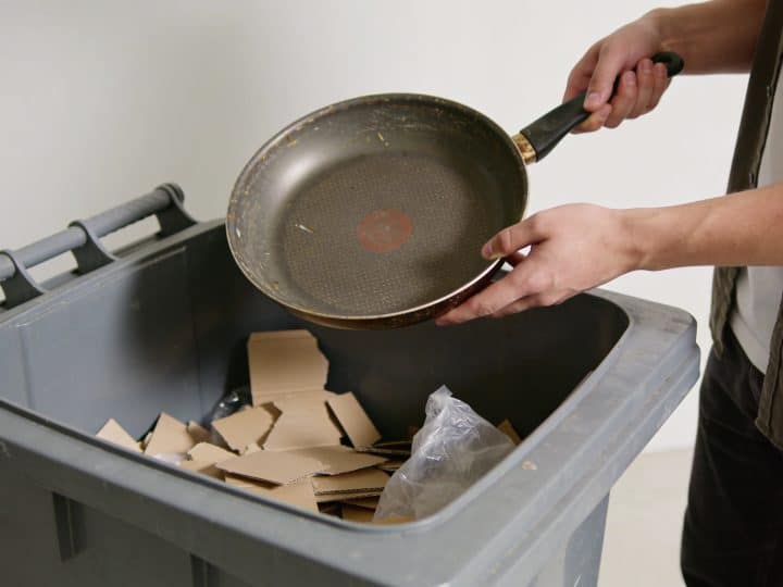 personne deposant une vieille poele dans benne dechet