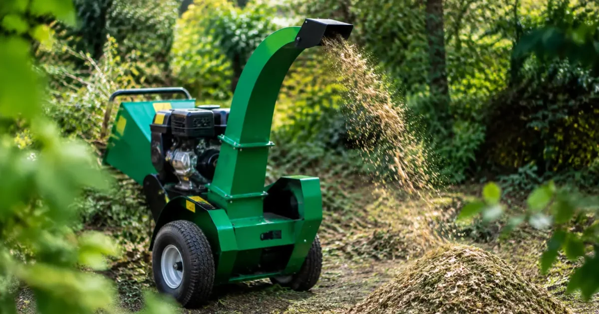 Broyeur vert deversant paillis de branches au sol