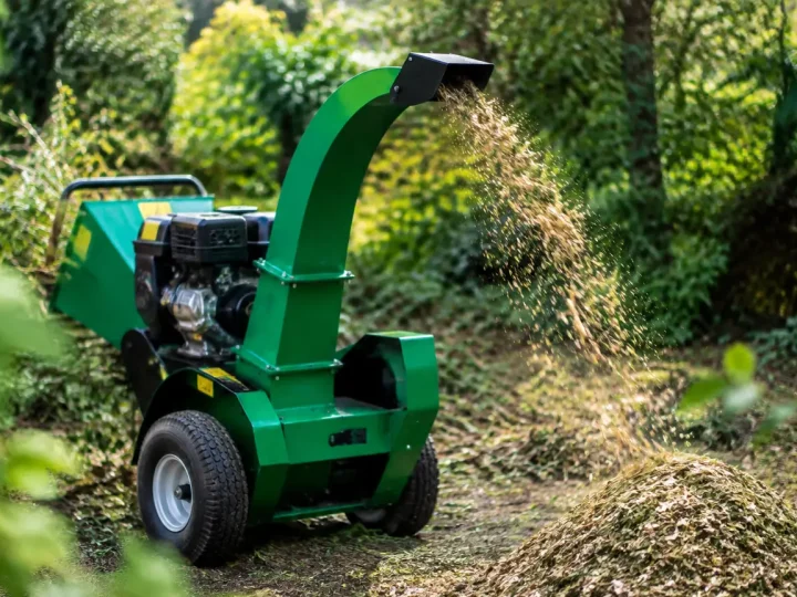 Broyeur vert deversant paillis de branches au sol