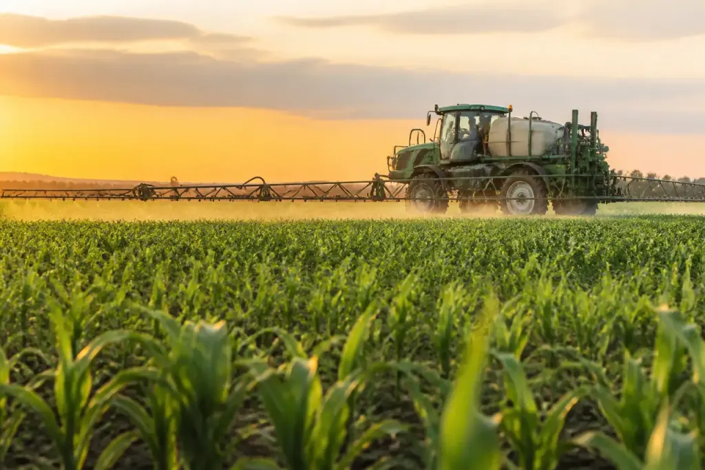 Tracteur pulverisateur avec rampe deployee dans un champ